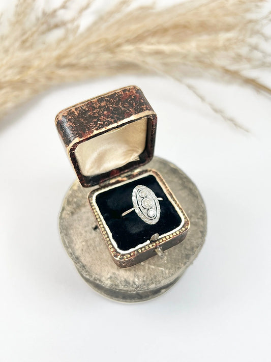 Antique 18 Carat White Gold Three Stone Diamond Oval Halo Ring, Circa 1910