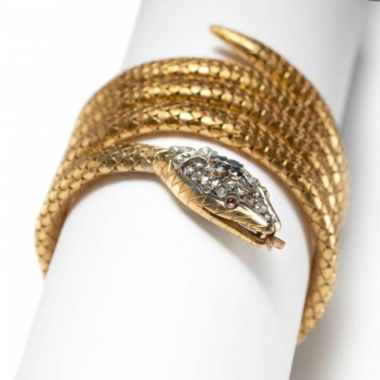 Antique Gold Snake Bracelet with Diamond Sapphire and Ruby; four coils of gold flexible links with scale detail, head set with faceted sapphires and rose-cut diamonds, cabochon-cut ruby eyes and gold tongue and teeth, Circa 1890