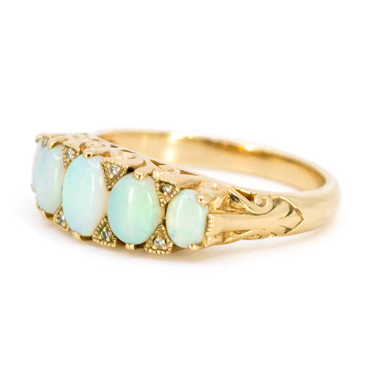 An opal and diamond graduating ring in yellow gold