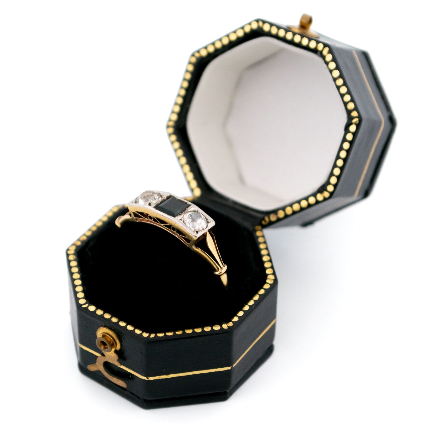 A three stone sapphire and diamond ring in yellow and white gold in a ring box