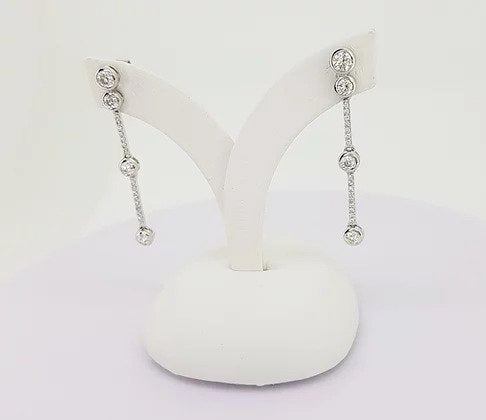 Contemporary Diamond Drops Earrings; featuring bezel set brilliant-cut diamonds linked via smaller diamond set links, 0.70 carat total, 18ct white gold.
