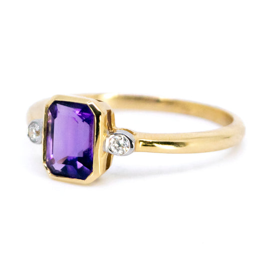 A three stone ring with amethyst and diamonds in yellow and white gold