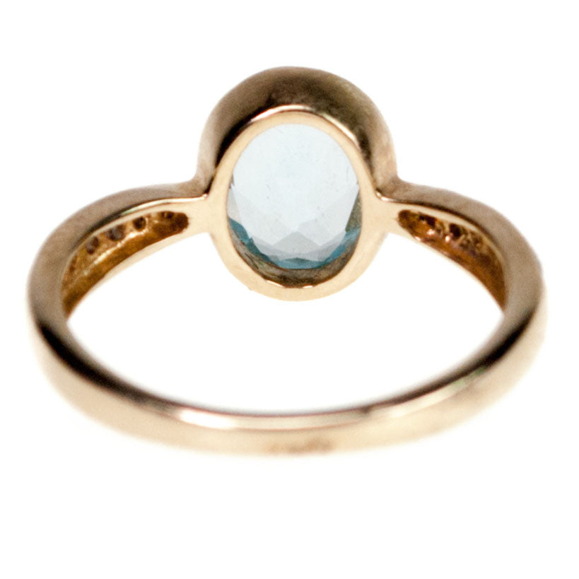 An oval blue topaz and diamond ring in yellow gold
