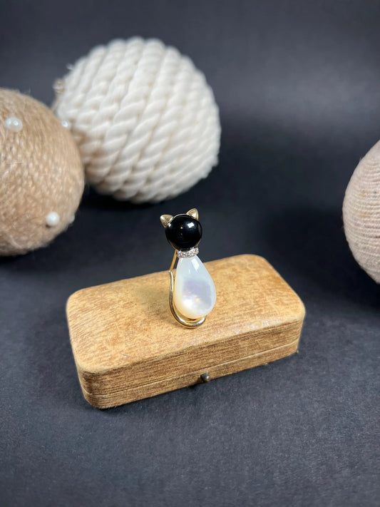 A cat-shaped brooch in yellow gold with black onyx, mother of pearl and a diamond set collar