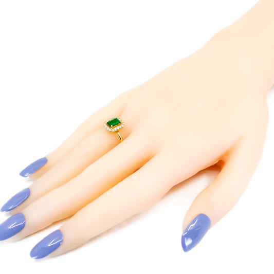 An emerald and diamond octagonal cluster ring in yellow gold, modelled on a hand