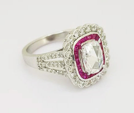 Oval Cut Diamond and Ruby Cluster Ring; oval-cut diamond surrounded by calibre-cut rubies and brilliant-cut diamonds, diamond set shoulders, 18ct white gold