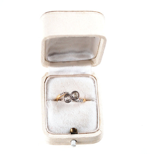 A two stone diamond crossover ring in yellow and white gold, in a ring box
