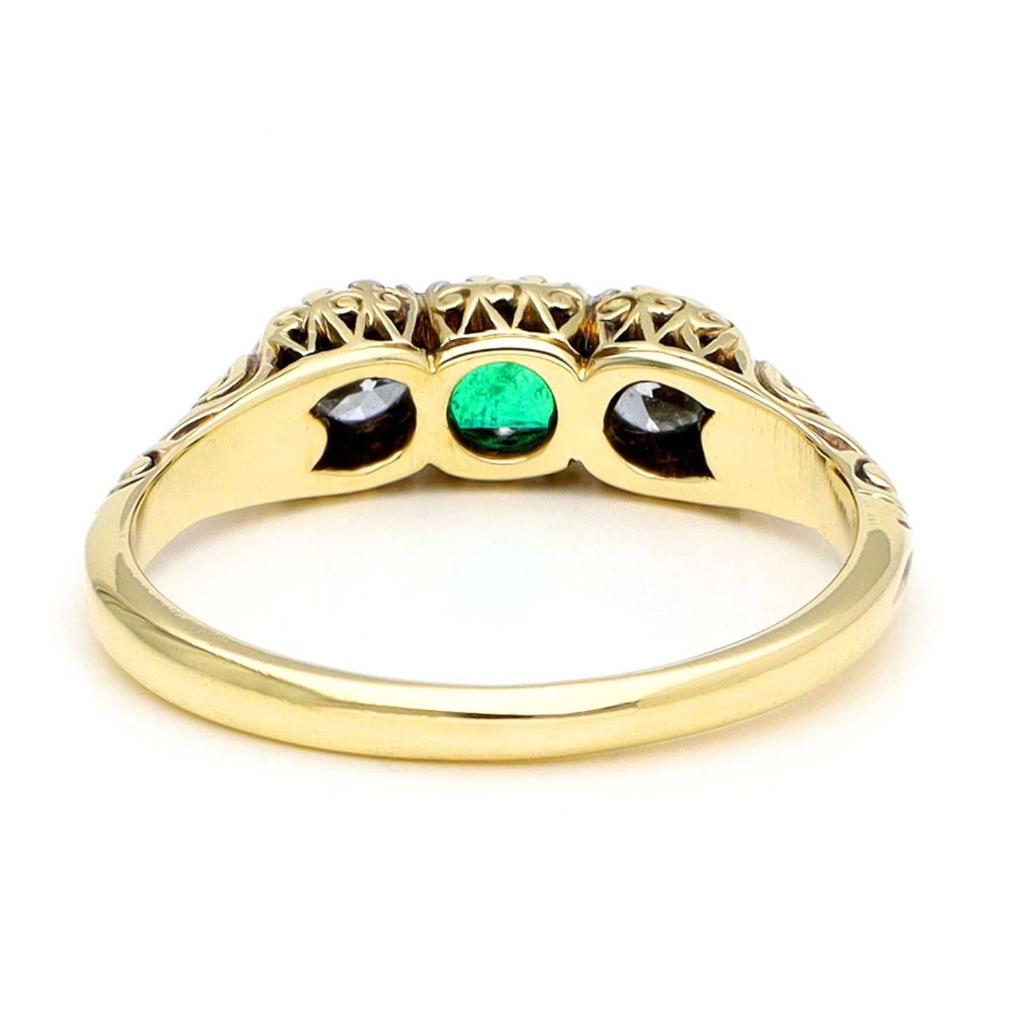 A yellow gold ring with scroll detailing, against a white background