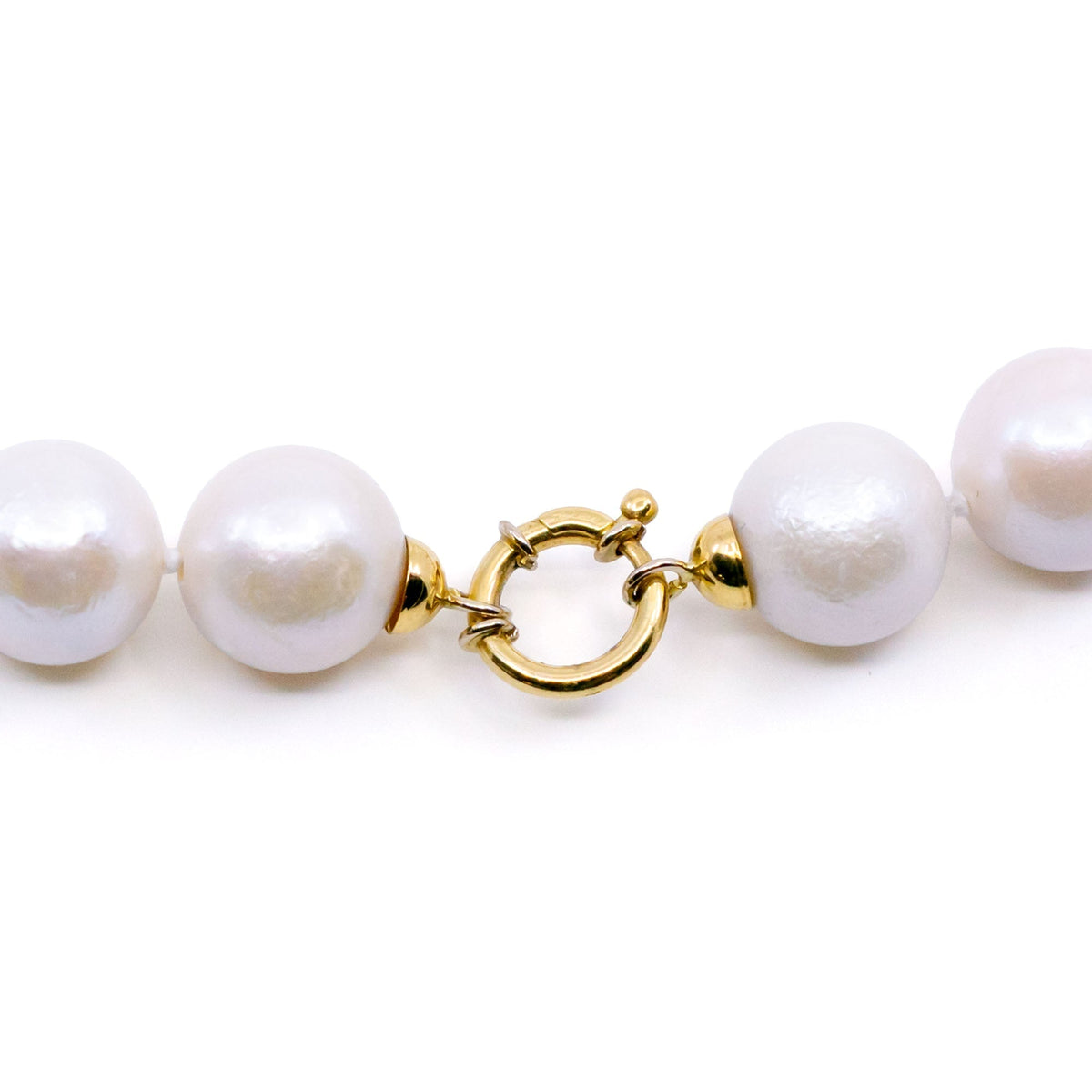 A white cultured pearl necklace, with a yellow gold clasp