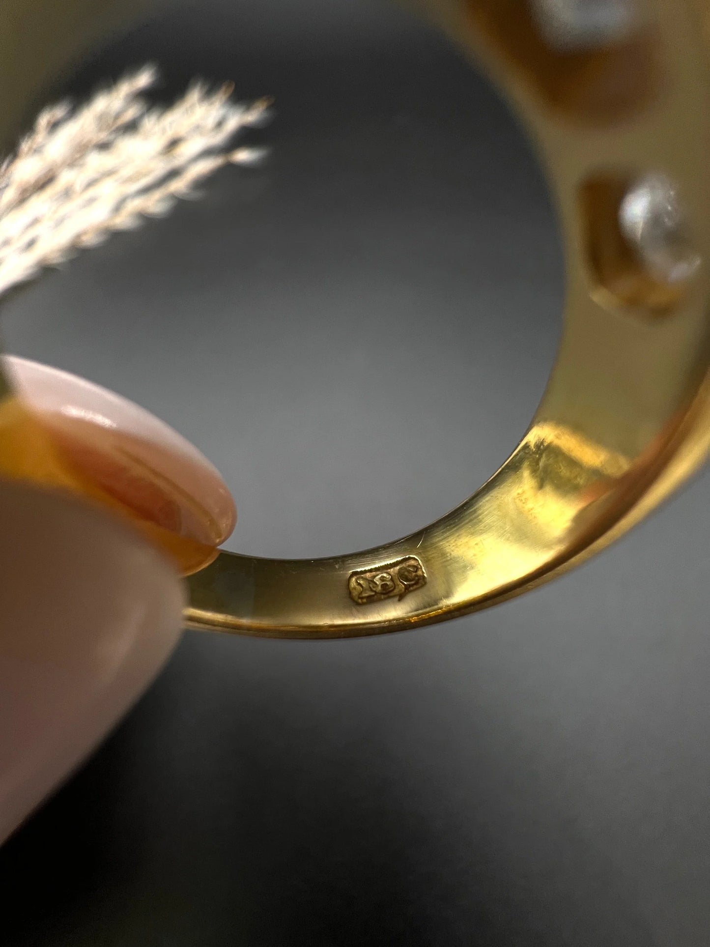 A close-up of an 18C stamp inside a gold ring shank