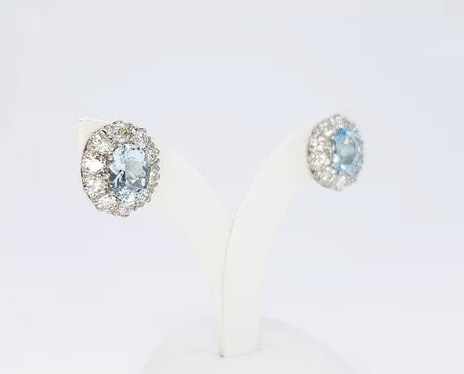 Aquamarine and Diamond Oval Cluster Earrings; 2.50cts oval aquamarines surrounded by 1.90cts round brilliant-cut diamonds, in 18ct white gold