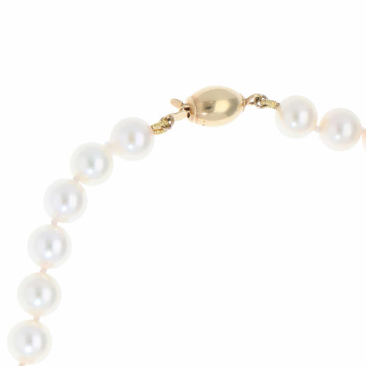 Akoya pearl necklace with a gold barrel clasp.
