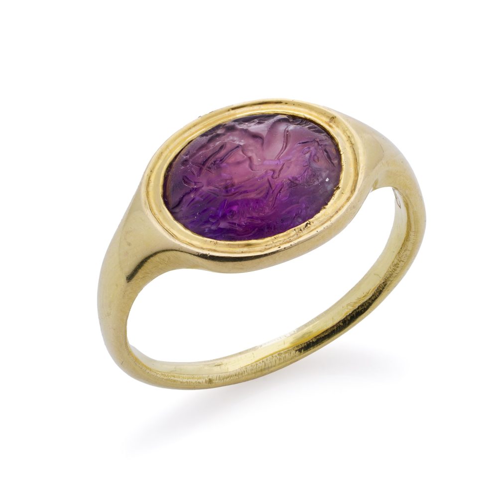 Roman carved intaglio amethyst ring featuring Eros riding a dolphin mounted in gold.