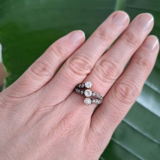 Victorian Antique Diamond Three Stone Banded Ring, diamond trilogy vertically set in asymmetrical design flanked by diamond banded shoulders in silver upon 18ct yellow gold