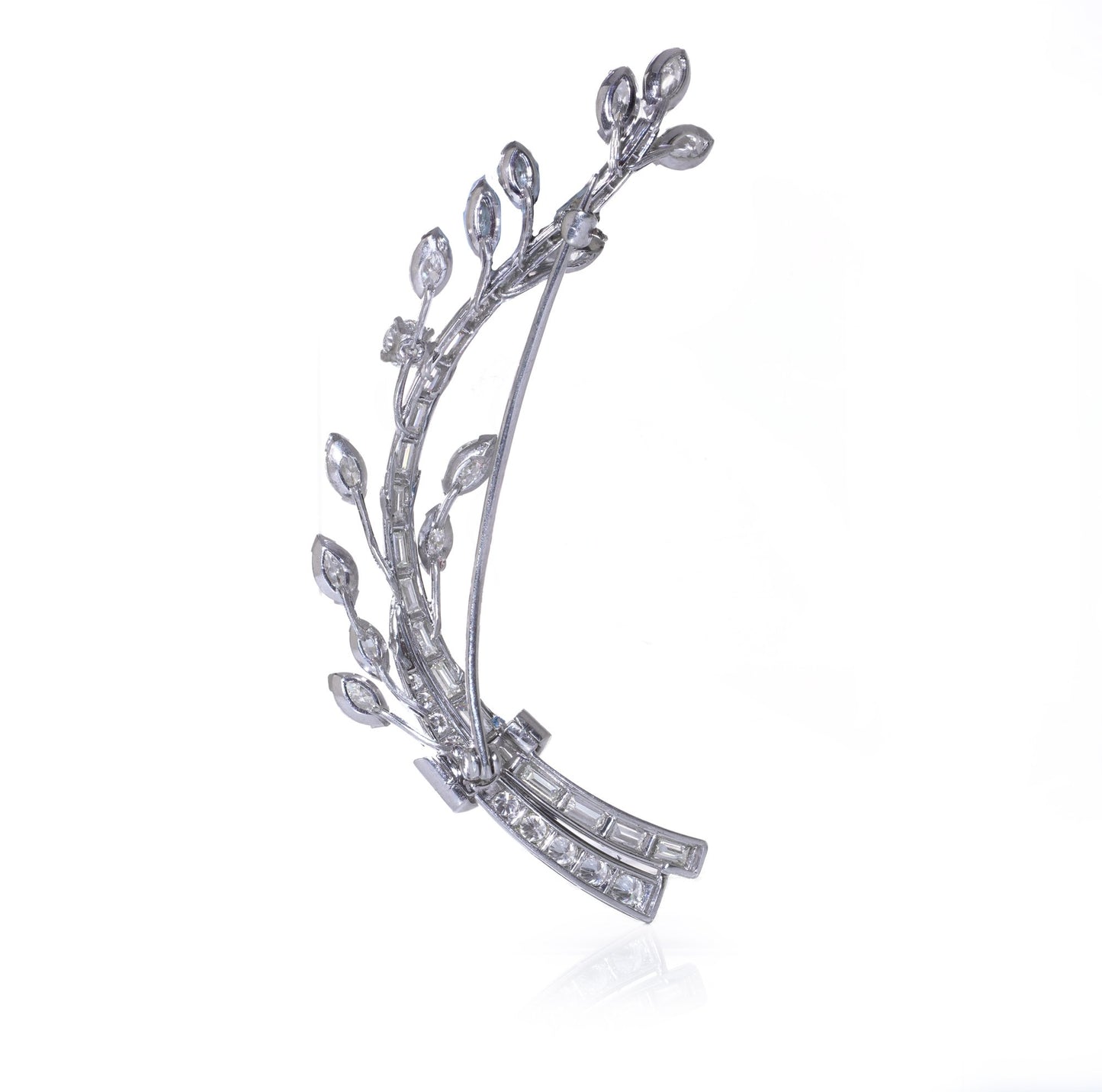A leaf design brooch set with baguette, marquise and brilliant cut diamonds in white metal, on a white background