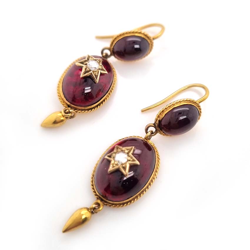 Victorian Antique Garnet and Diamond Drop Earrings, oval cabochon garnets suspend larger oval garnets with rose cut diamonds set to central stars in 18ct yellow gold with twisted gold wire surrounds and gold conical tear drops. Late 19th century Circa 1870