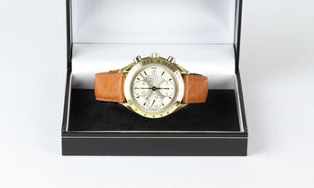 Omega Speedmaster 39mm Automatic Chronograph 18ct Yellow Gold, Silver and white baton dial, date indicator at 3, small seconds at 9, on brown leather strap.