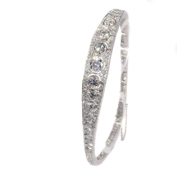 Art Deco Diamond and Platinum Bangle Bracelet, 6.01 carat total, seven central graduated old mine-cut diamonds totalling 2.75cts surrounded by 0.84cts old mine-cut and 2.42cts eight-cut diamonds. Circa 1920