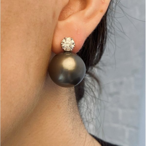 South Sea Pearl and Diamond Earrings; one black and one white South Sea cultured pearl, each topped with a round brilliant-cut diamond, 2.20 carat total, in white gold