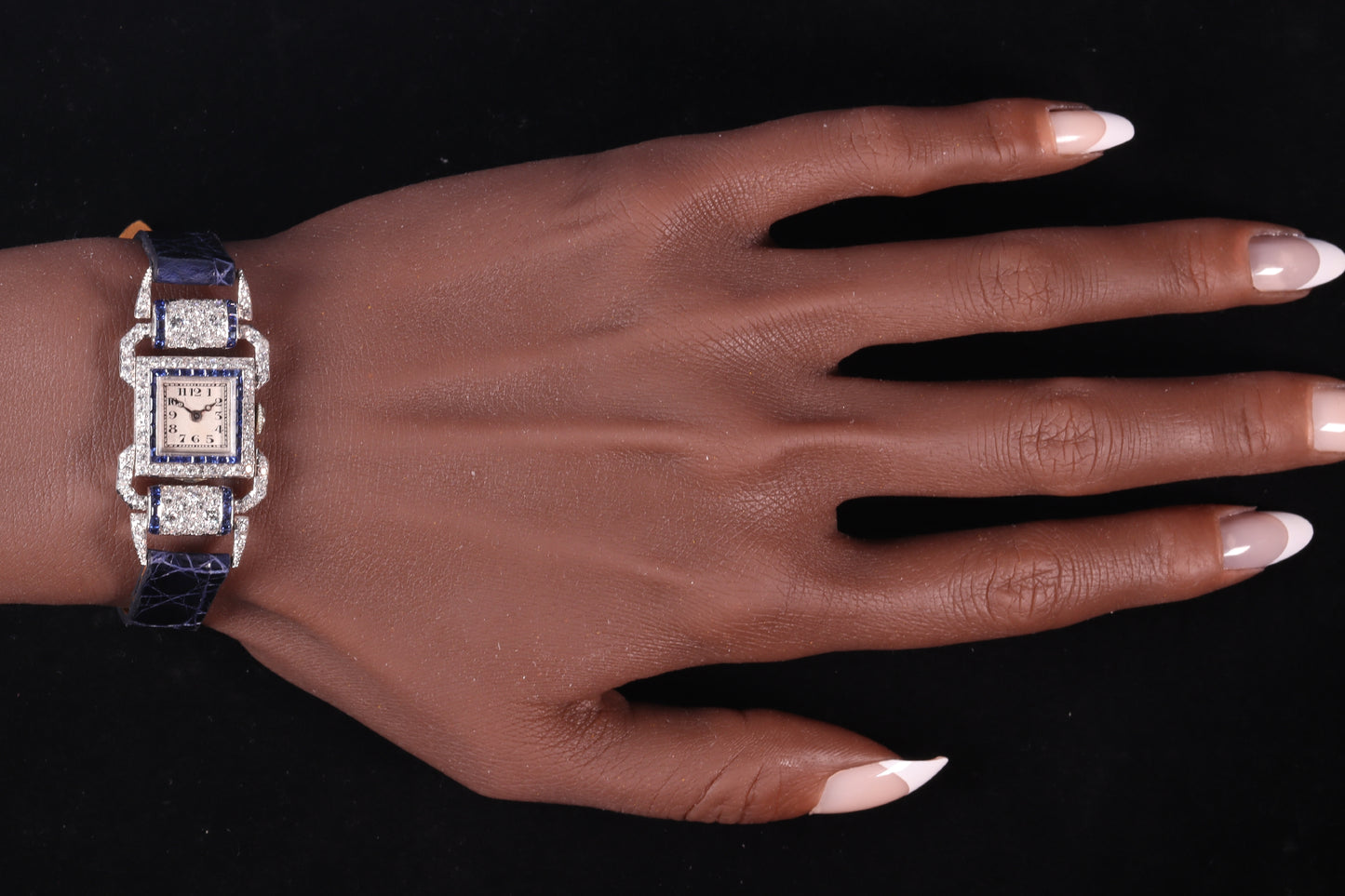 A ladies Art Deco design cocktail wristwatch set with diamonds and sapphires, on a blue leather strap, modelled on a wrist
