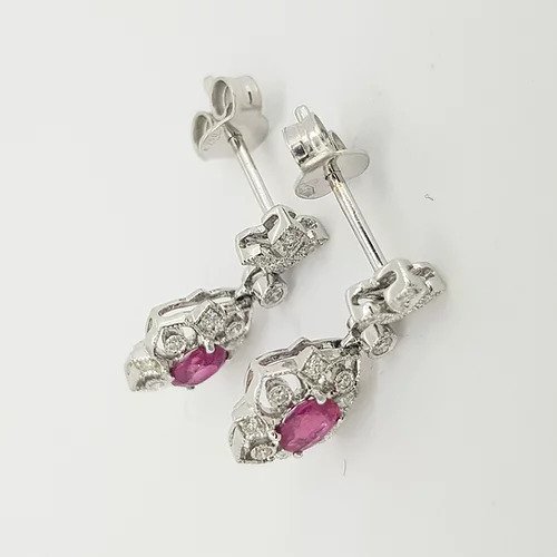 Edwardian Style Ruby and Diamond Cluster Drop Earrings; oval faceted rubies within diamond set openwork cluster surround, suspended from a diamond set fleur-de-lis stud. Mounted in 18ct white gold.
