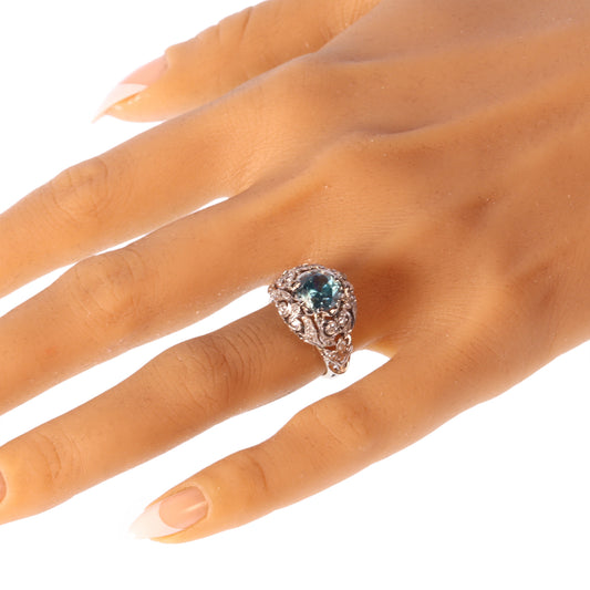 A round blue zircon and diamond openwork ring in platinum, modelled on a hand