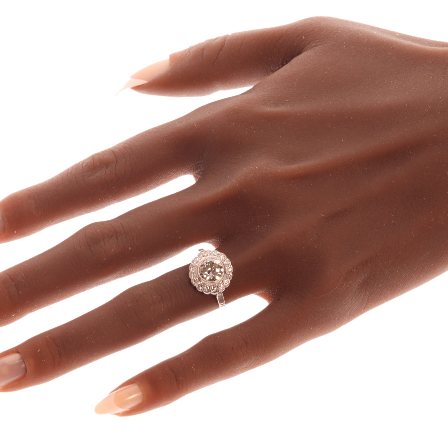 A brilliant cut diamond scalloped edge cluster ring in platinum modelled on a hand