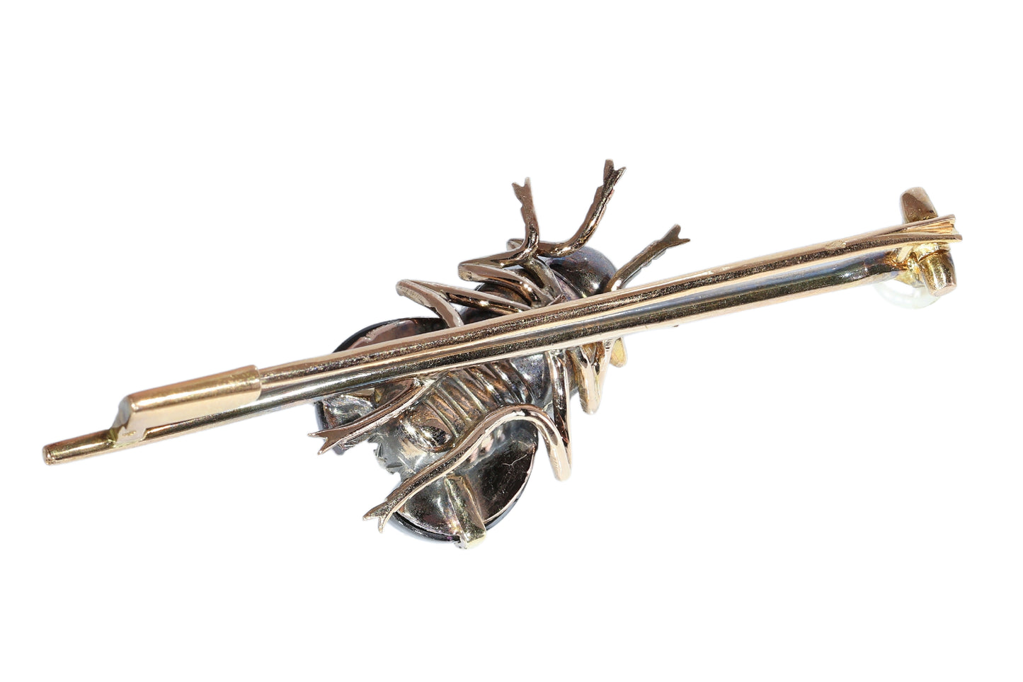 An antique gold bar brooch with a diamond, garnet and ruby set insect in the centre