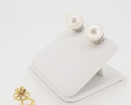 Pearl and Diamond Stud Earrings; featuring cultured pearl studs accented with micro-set diamond collars. Mounted in 18ct white gold.