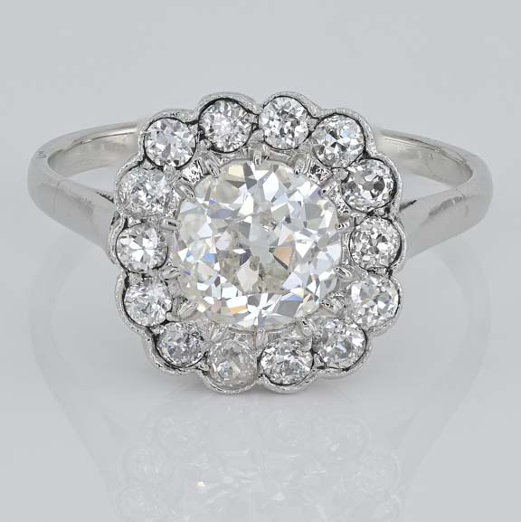 Late Art Deco Diamond Cluster Engagement Ring, 1.60 carats, 1.15ct old European cut diamond within 0.45ct sparkling diamond surround in platinum. Circa 1935