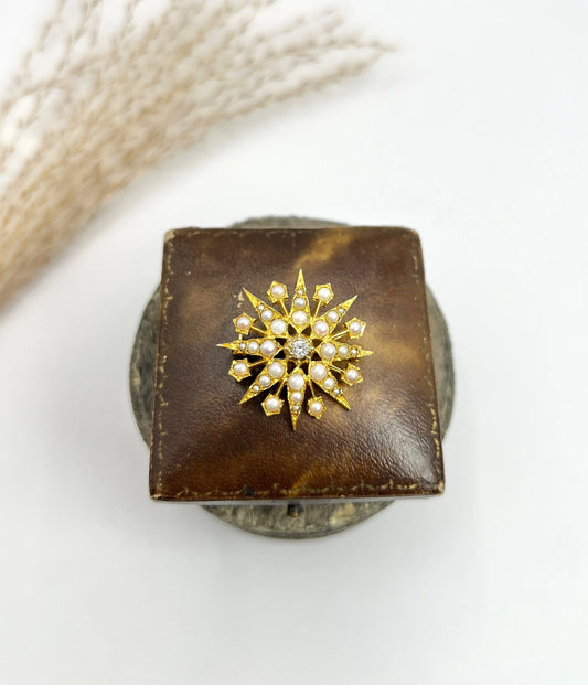 A star-shaped pearl and diamond brooch/pendant in yellow gold