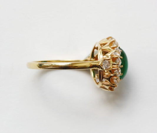 Antique Edwardian Oval Cabochon Emerald and Diamond Cluster Ring; 2.70ct oval cabochon cut emerald surrounded by 1.65cts old-cut diamonds, 18ct yellow gold