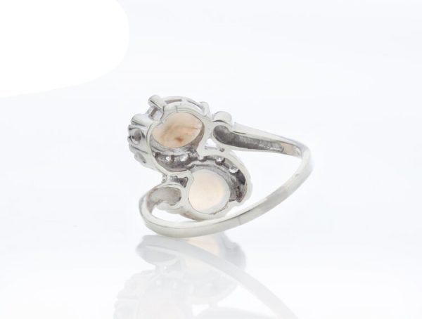 Vintage 1.50ct Opal and Diamond Crossover Ring; set with two opals enveloped by 0.18cts diamonds, 14ct white gold, Circa 1960s