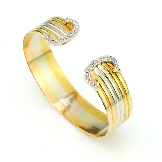 Vintage Cartier Diamond Set 18ct Gold Trinity Bangle Bracelet; double C collection de Cartier 18ct yellow, rose and white gold bangle with the iconic diamond set C de Cartier motif on each end, totalling 0.74 carats. Made in France, Circa 1980s