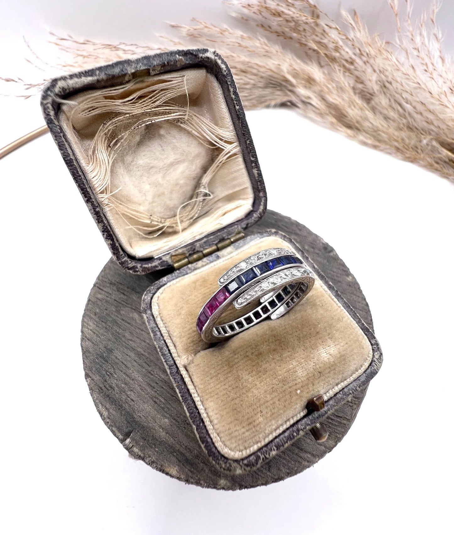 A platinum night and day flip band ring set with diamonds, sapphires and rubies, in a ring box