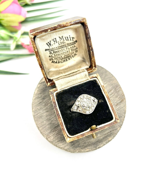 An antique diamond cluster ring in gold and silver, in an antique ring box