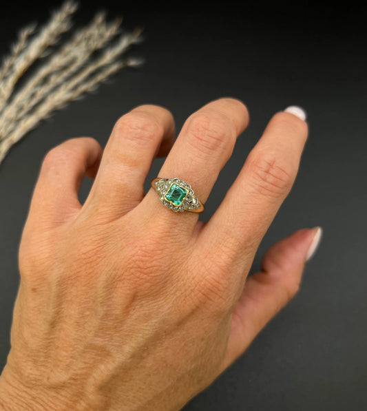 An emerald and diamond square shaped cluster ring, modelled on a hand