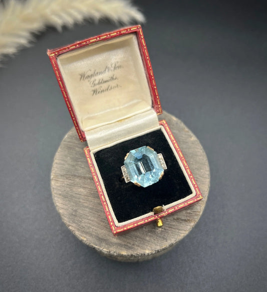 An octagonal cut aquamarine and diamond cocktail ring in yellow gold, in an antique ring box