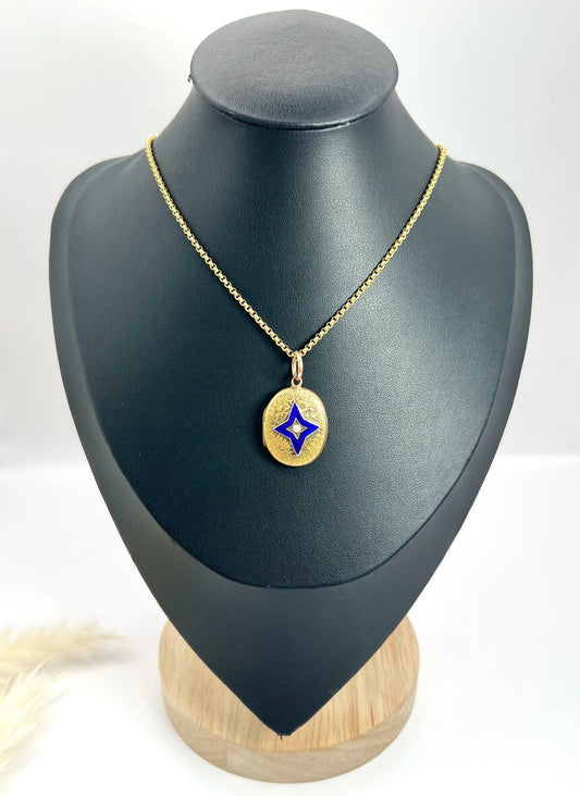 An oval yellow gold locket with a blue enamel star and seed pearl centre, on a chain