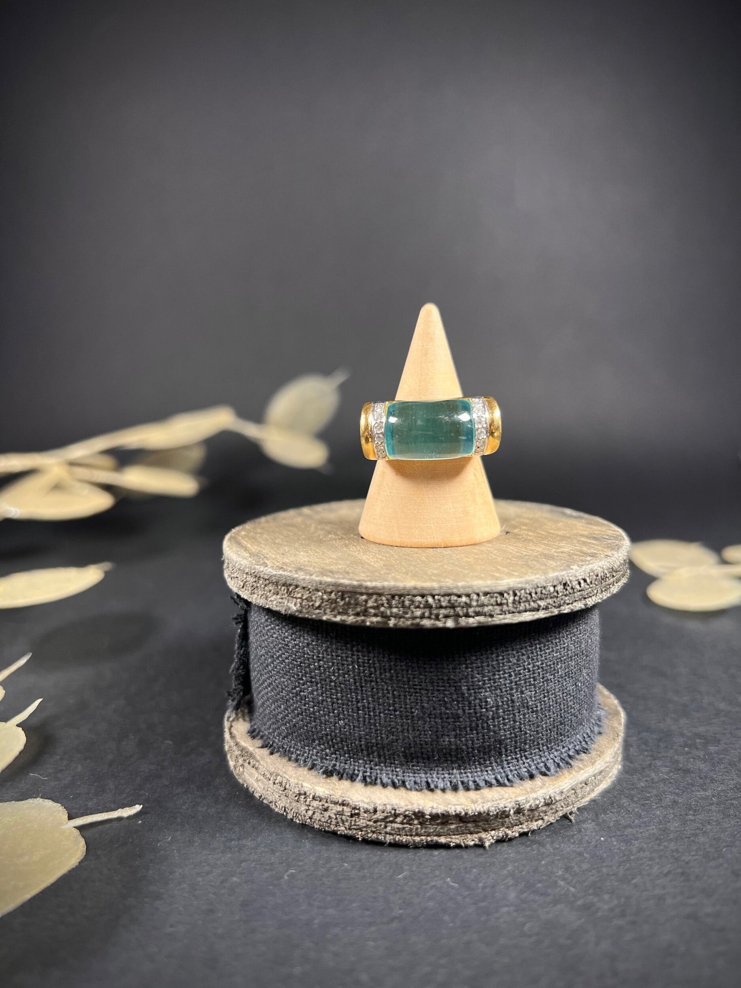 A blue topaz and diamond ring in yellow gold, on a ring cone