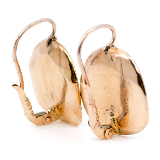 A pair of gold earrings on a white background