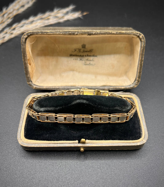 A gold and platinum gate bracelet, in an antique box