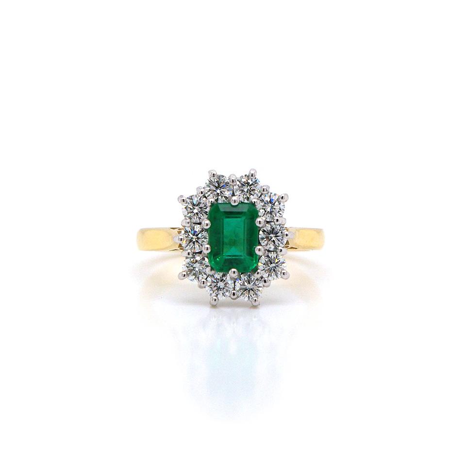 Emerald and diamond cluster ring in yellow and white gold.