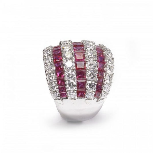 Contemporary Ruby and Diamond Bombe Cocktail Ring; seven alternating rows of 3.50cts calibre-cut rubies and 2.50cts round brilliant cut diamonds, claw and channel set in 18ct white gold, Circa 1990