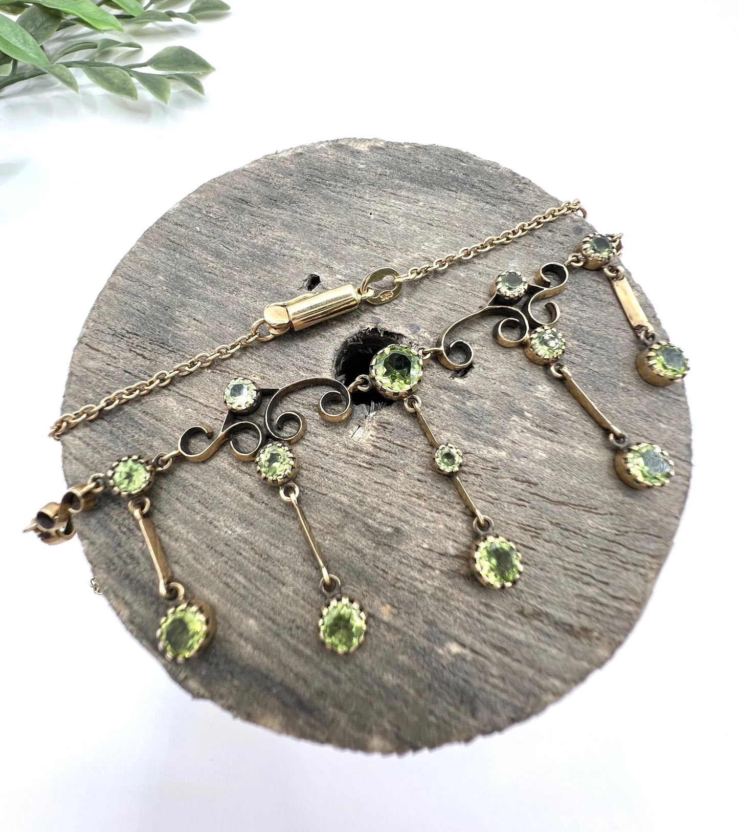 A yellow gold swag necklace with peridot drops