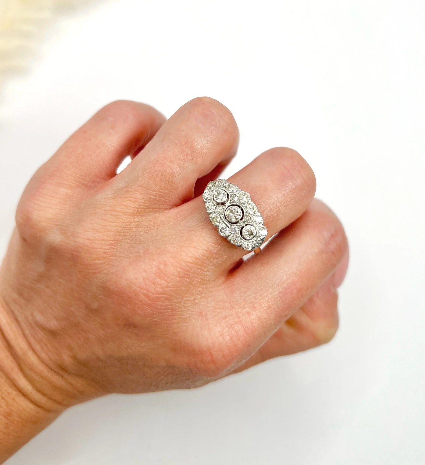 A diamond triple cluster ring in yellow and white gold, modelled on a hand