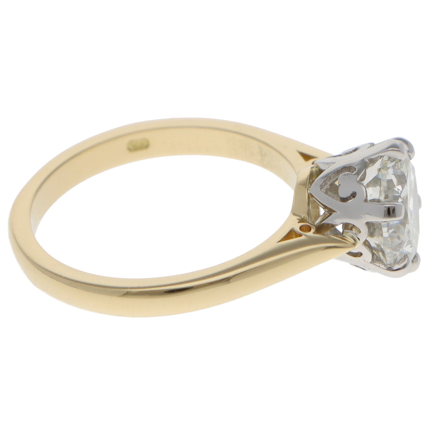 A single stone round brilliant cut diamond ring in yellow gold and platinum, on a white background