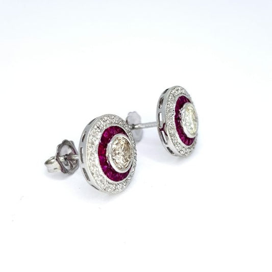 Calibre Ruby and Diamond Target Cluster Earrings; central brilliant-cut diamonds surrounded by calibre-cut rubies, all within outer diamond border, in 18ct white gold