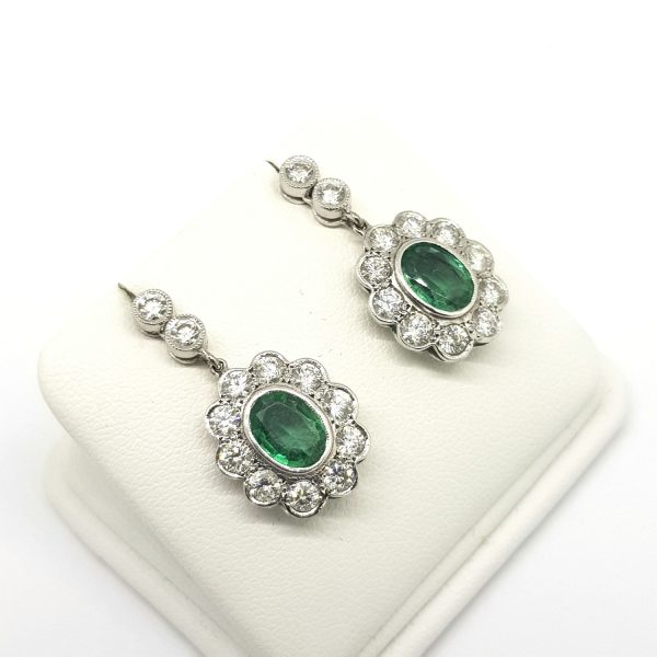 Emerald and Diamond Floral Cluster Drop Earrings; featuring 3.03cts oval faceted emeralds surrounded by 2.01cts brilliant-cut diamonds, in 18ct white gold