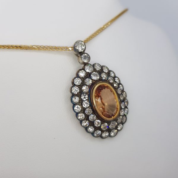 Vintage Brazilian Topaz and Diamond Cluster Pendant; central 4ct orange oval Brazilian topaz with double double surround and diamond-set bale